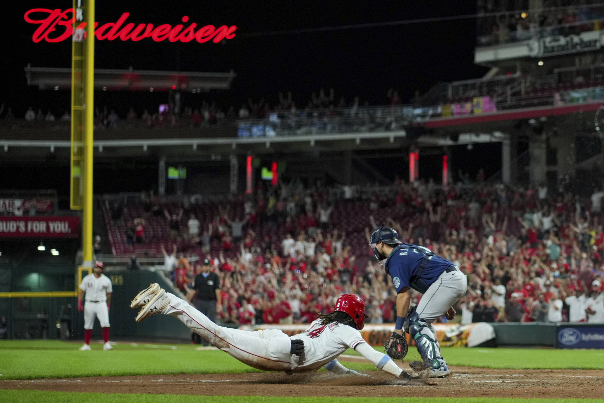 The Reds’ Elly De La Cruz scores the game-winning run on a single by Christian Encarnacion-Strand during the ninth inning of a game against the Mariners on Tuesday in Cincinnati. (AP Photo/Aaron Doster)