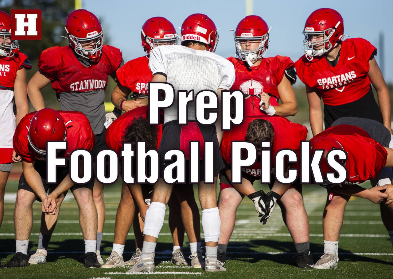 Stanwood's Michael Mascotti relays the next play to his teammates during football practice on Monday, Aug. 29, 2022 in Stanwood, Washington. (Olivia Vanni / The Herald)