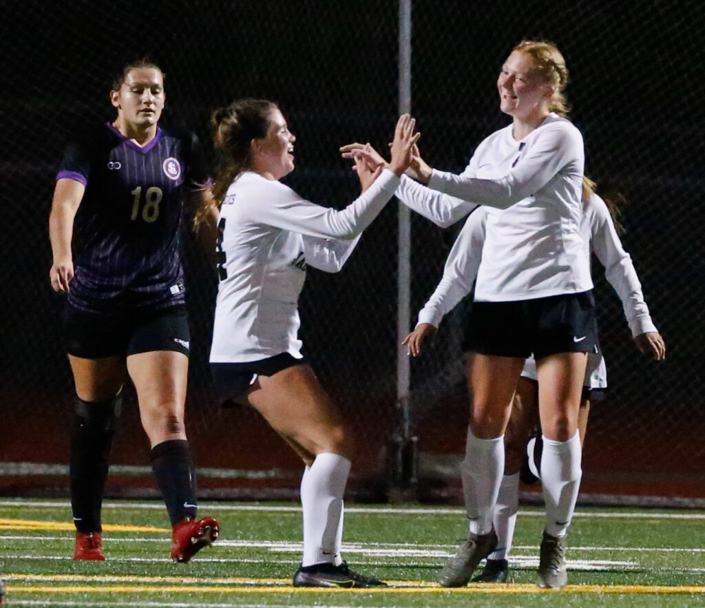 Jackson’s Tia Schwetz (right) celebrates a goal against Lake Stevens on Sept. 28, 2021, at Lake Stevens High School. (Kevin Clark / The Herald)
