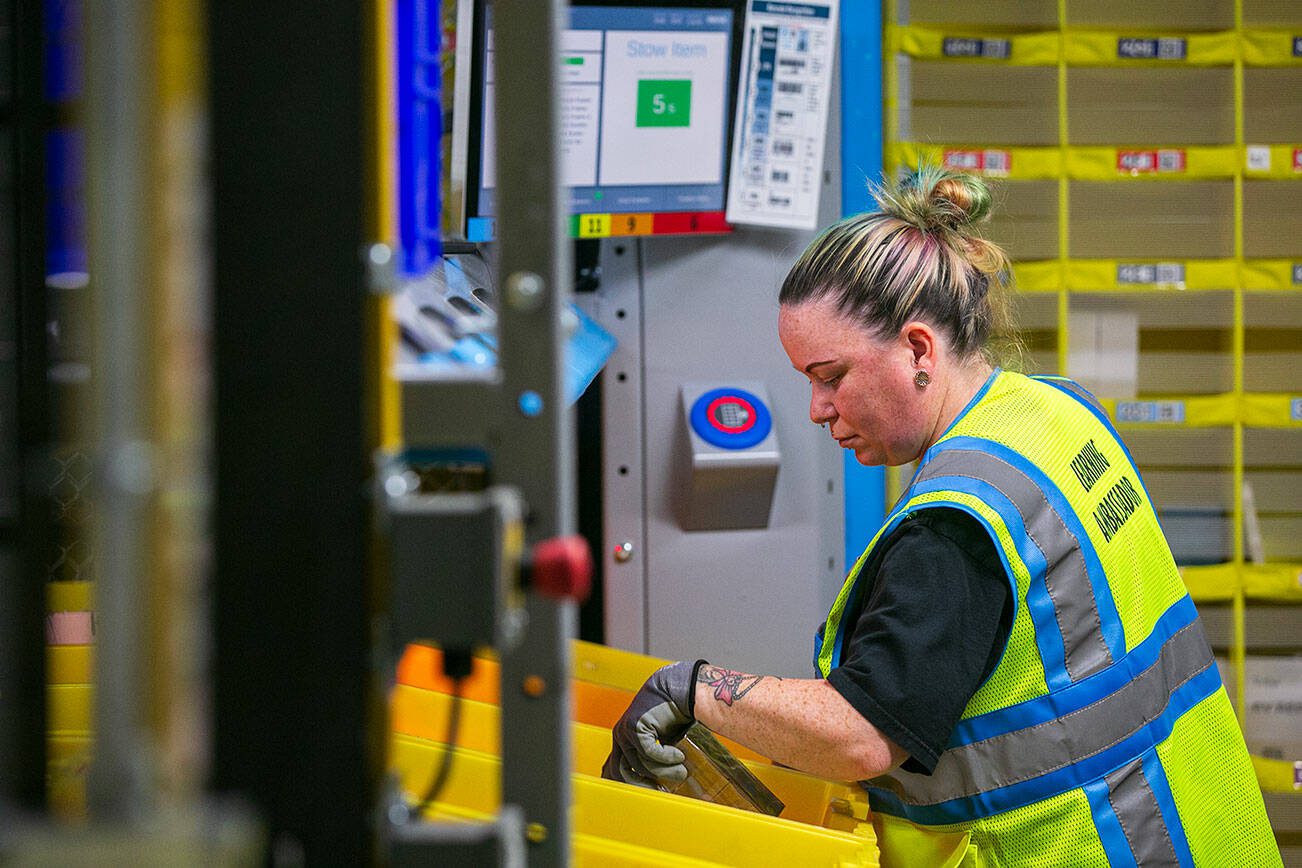 An Amazon worker transfers and organizes items at the new PAE2 Amazon Fulfillment Center on Thursday, Sept. 14, 2023, in Arlington, Washington. (Ryan Berry / The Herald)