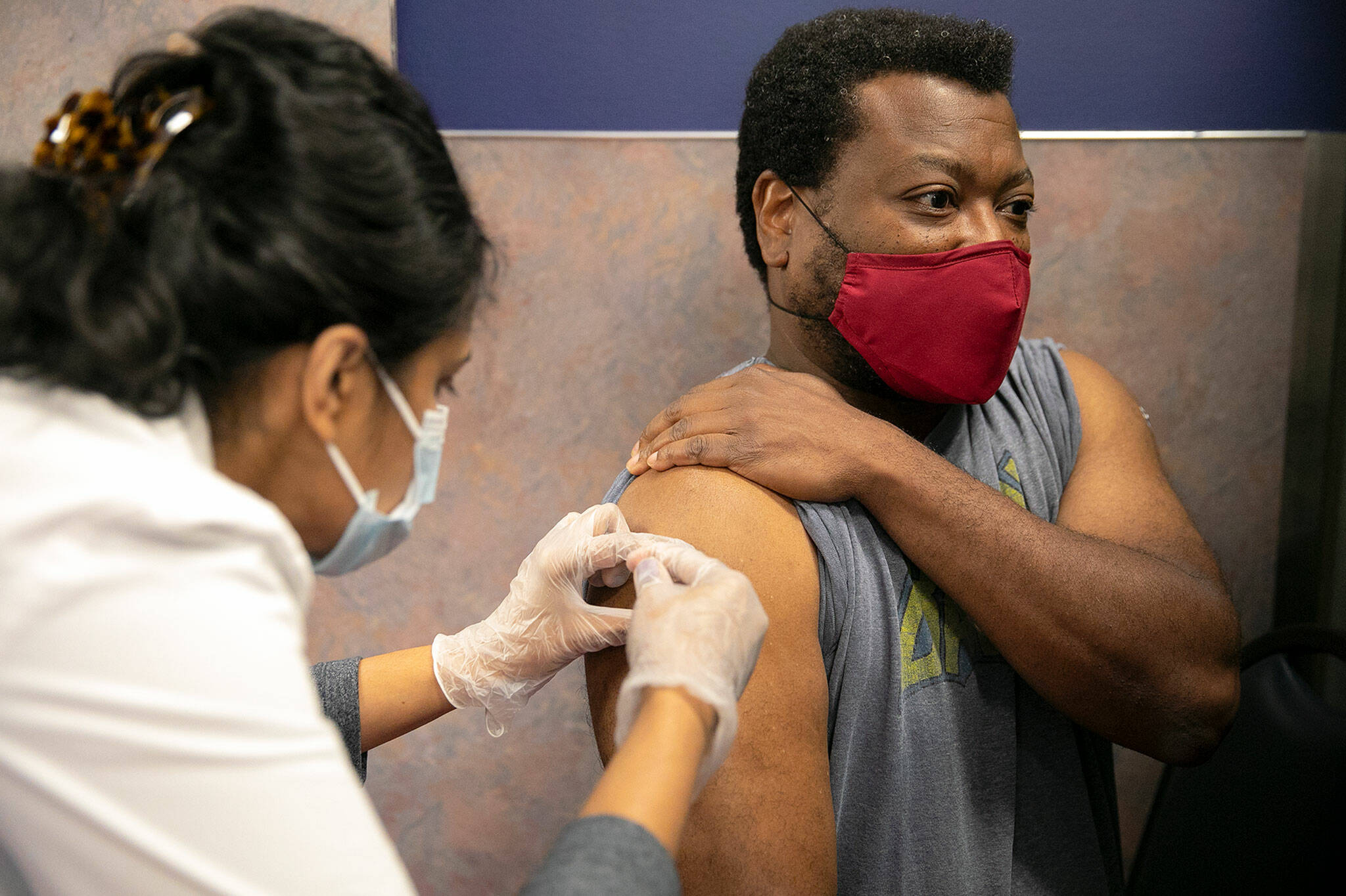 Everett resident Shon Grimes receives a flu shot from pharmacist Nisha Mathew at Bartell Drugs on Broadway on Saturday, Oct. 1, 2022, in Everett, Washington. (Ryan Berry / The Herald)