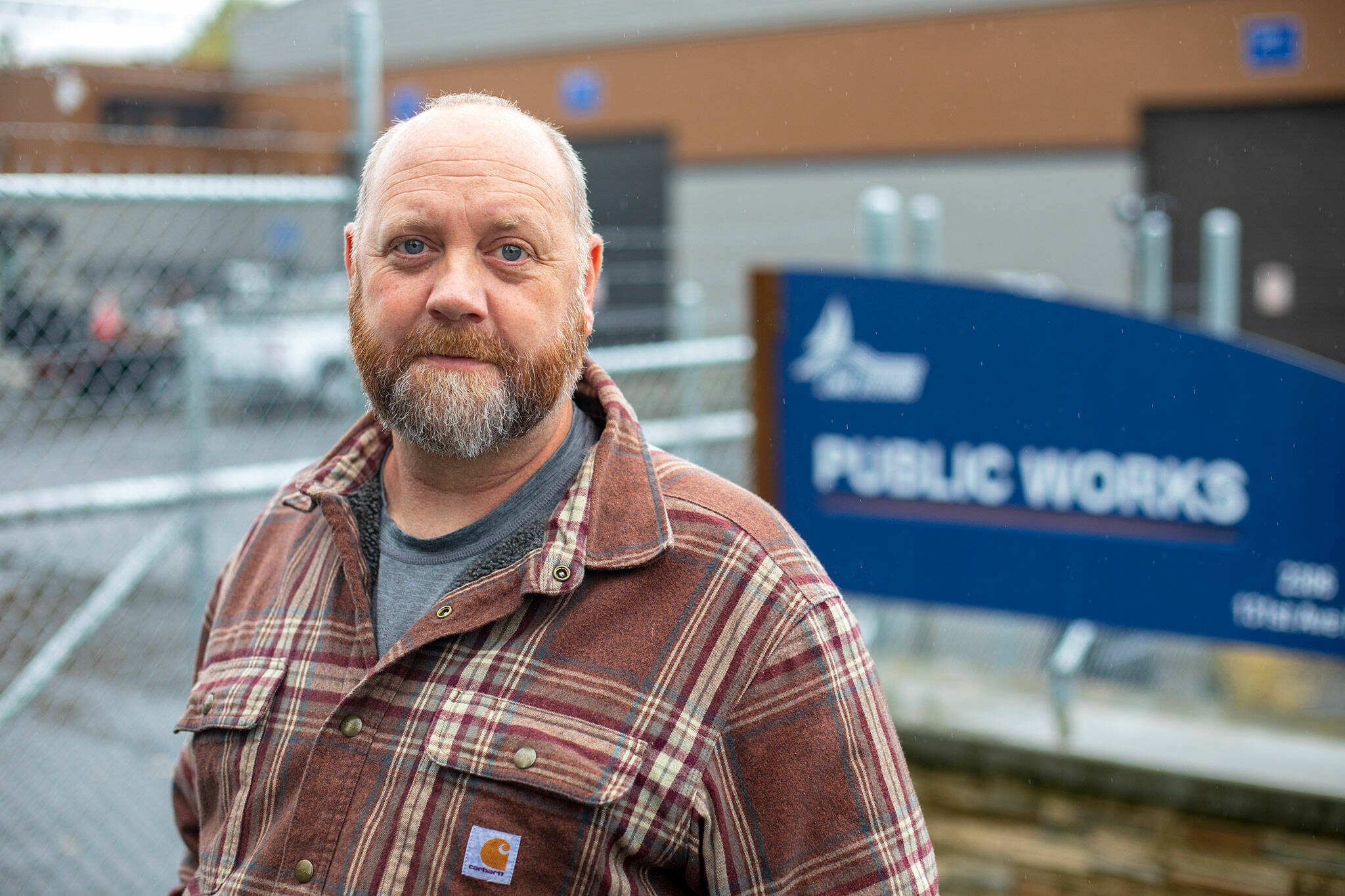 Mike Bredstrand, who is trying to get back his job with Lake Stevens Public Works, stands in front of the department’s building on Wednesday, Sept. 27, 2023, in Lake Stevens, Washington. Bredstrand believes his firing in July was an unwarranted act of revenge by the city. (Ryan Berry / The Herald)