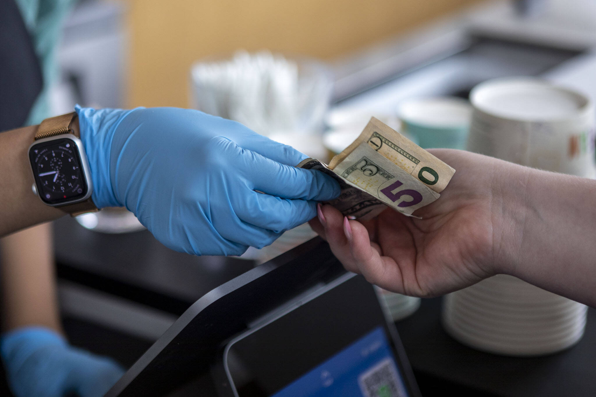 Cash is used for a purchase at Molly Moon’s Ice Cream in Edmonds, Washington Aug. 30, 2023. (Annie Barker / The Herald)