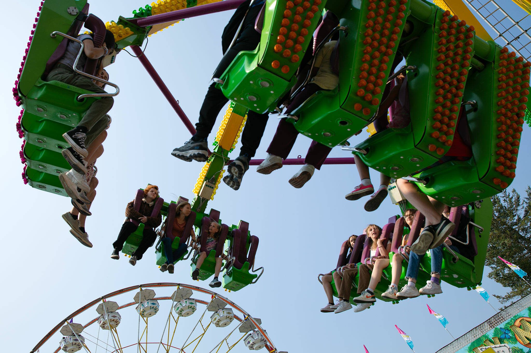 Thrill seekers fly through the air on a ride during opening day of the Evergreen State Fair on Thursday, August 24, 2023, in Monroe, Washington. (Ryan Berry / The Herald)