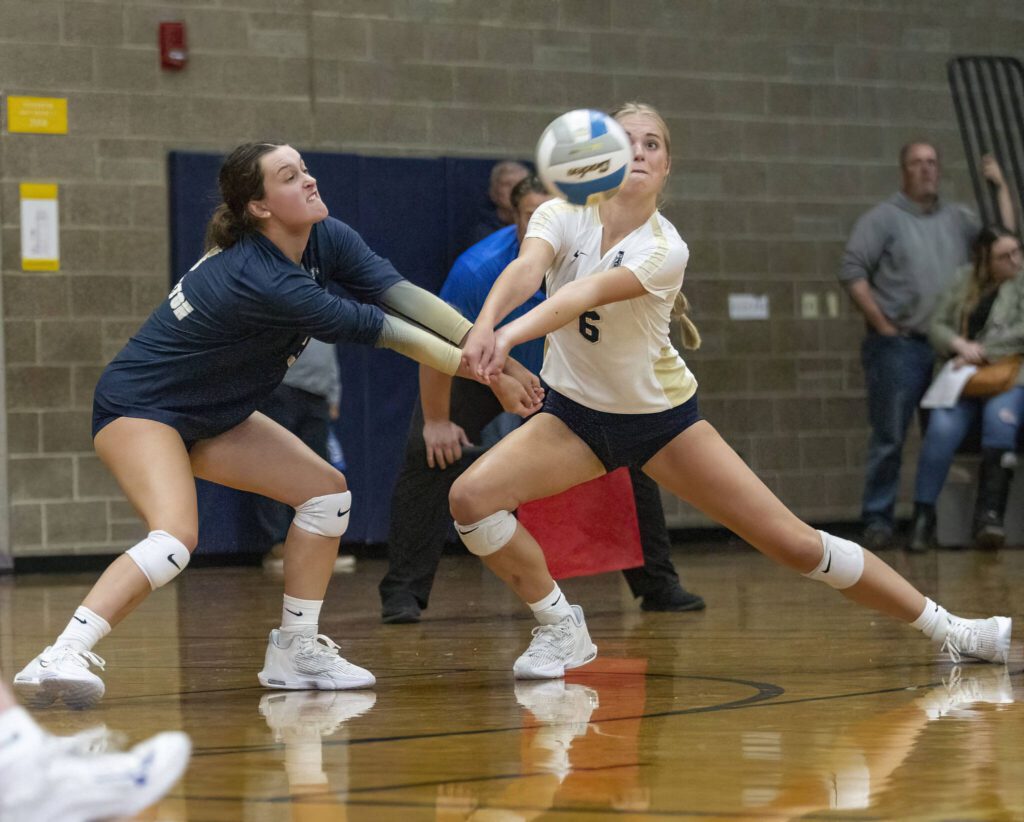 Arlington’s Savannah Roberts, left, and Emme Shaffer, right, collide while both going for a dig during the game against Stanwood on Tuesday, Sept. 19, 2023 in Arlington, Washington. (Olivia Vanni / The Herald)
