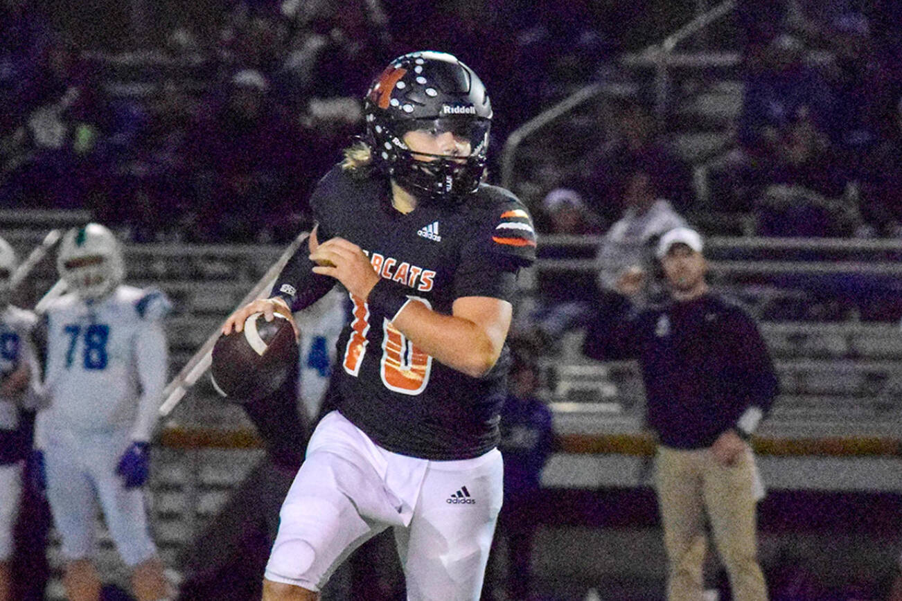 Monroe junior quarterback Blake Springer looks for an open receiver on Friday, Nov. 4, 2022 in Monroe, Washington. (Katie Webber / The Herald)