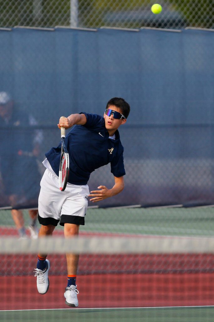 Arlington’s Robbie Balderas serves to an opponent during a matchup with Everett High on Monday, Sept. 18, 2023, at his school’s home court in Arlington, Washington. (Ryan Berry / The Herald)
