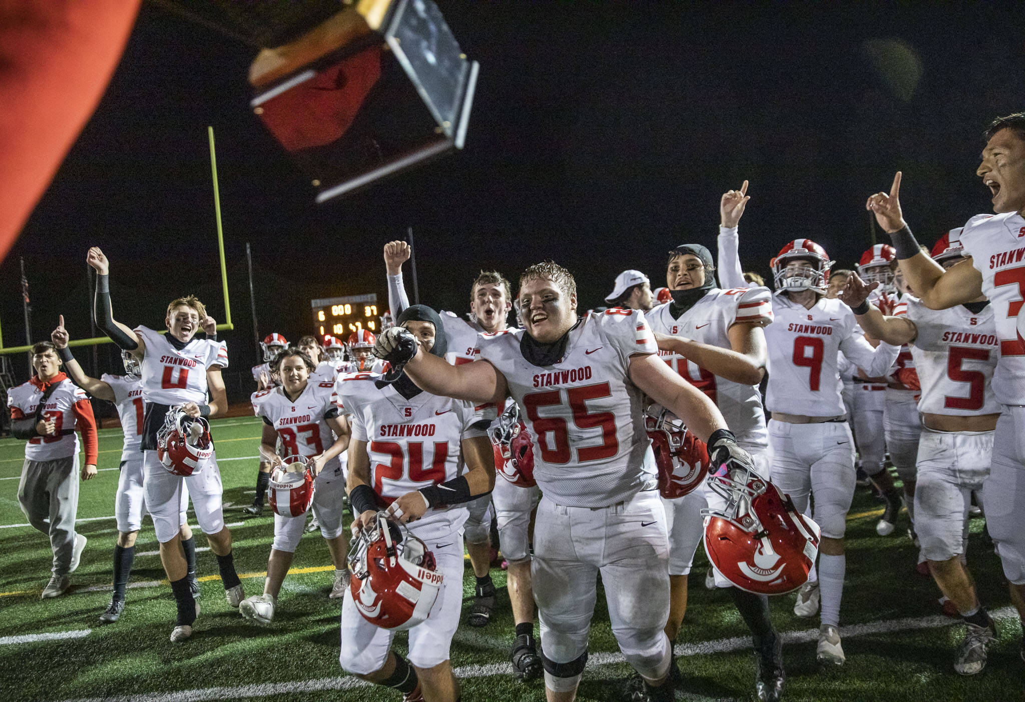 Stanwood players react to their coach bringing them the Stilly Cup on Sept. 30, 2022 in Arlington. The Spartans snapped a 12-game losing streak in the rivalry matchup last year. (Olivia Vanni / The Herald)