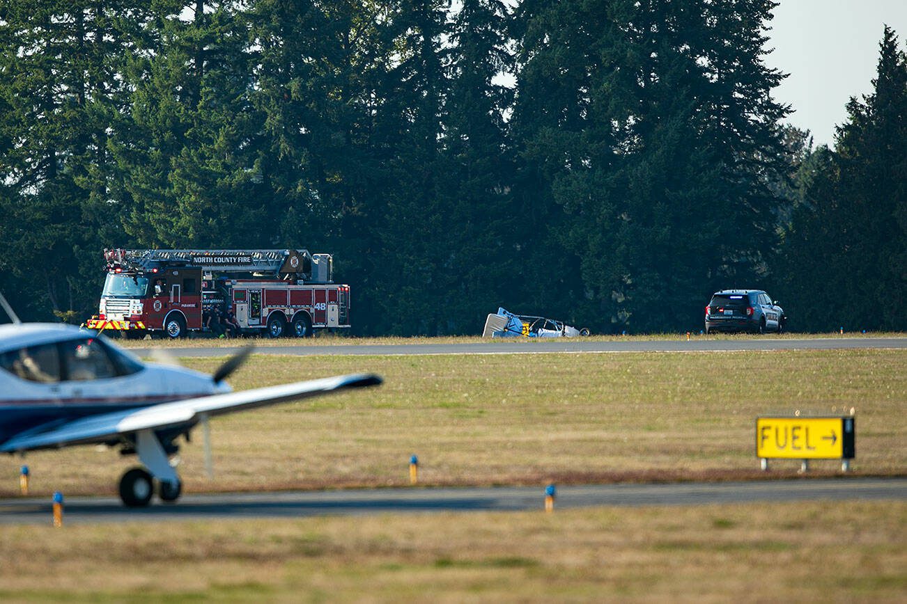 Emergency responders surround an ultralight airplane that crashed Friday, Sept. 22, 2023, at the Arlington Municipal Airport in Arlington, Washington, resulting in the pilot's death. (Ryan Berry / The Herald)