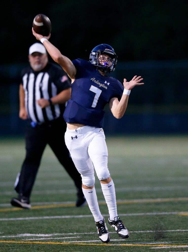 Arlington quarterback Leyton Martin connects on a rollout pass against Ferndale on Friday, Sept. 22, 2023, at Arlington High School in Arlington, Washington. (Ryan Berry / The Herald)
