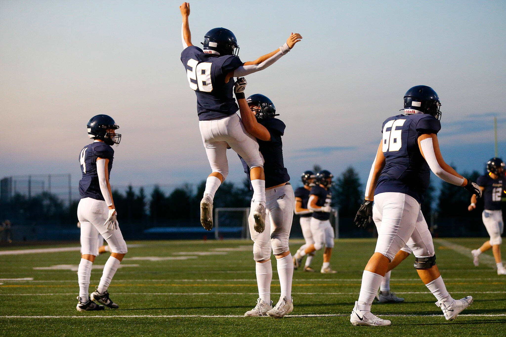 Arlington’s Caleb Reed is thrown into the air by lineman Dylan Scott after scoring a touchdown against Ferndale on Friday, Sept. 22, 2023, at Arlington High School in Arlington, Washington. (Ryan Berry / The Herald)