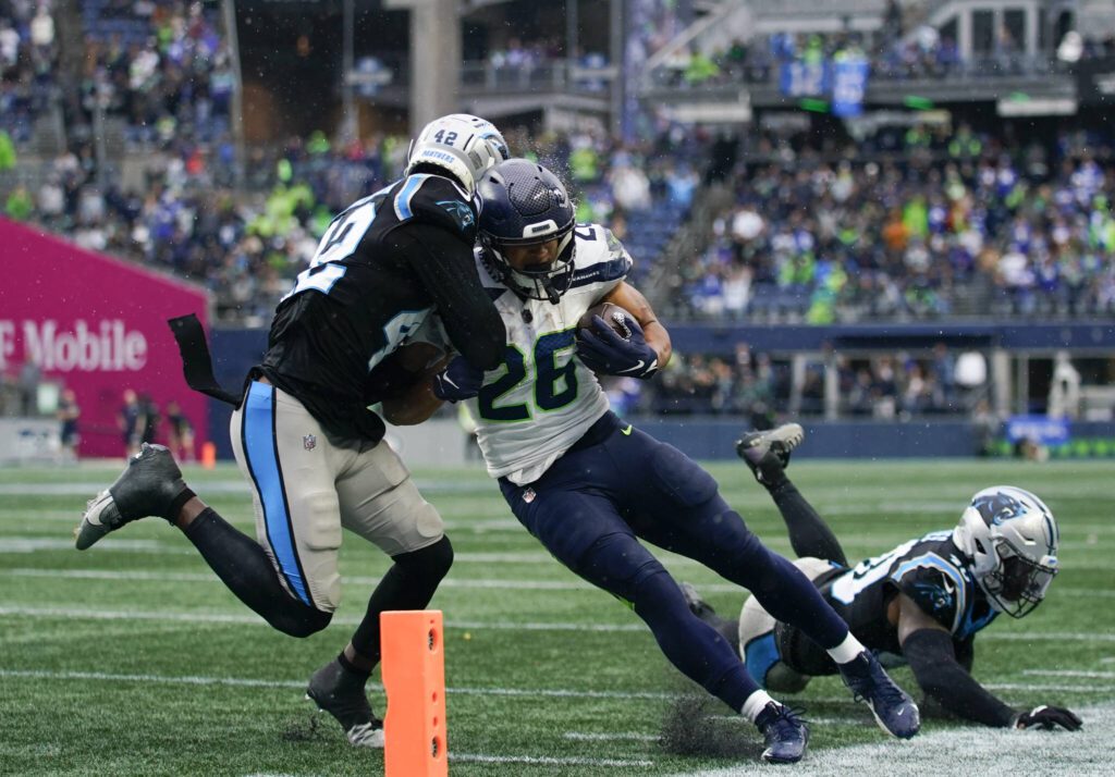 Seahawks running back Zach Charbonnet (26) lowers his shoulder into Panthers safety Sam Franklin Jr. during a game Sunday in Seattle. (AP Photo/Lindsey Wasson)
