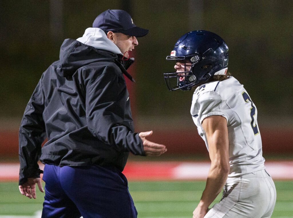 Arlington’s Chase Deberry celebrates with his coach during the game against Stanwood on Friday, Sept. 29, 2023 in Stanwood, Washington. (Olivia Vanni / The Herald)
