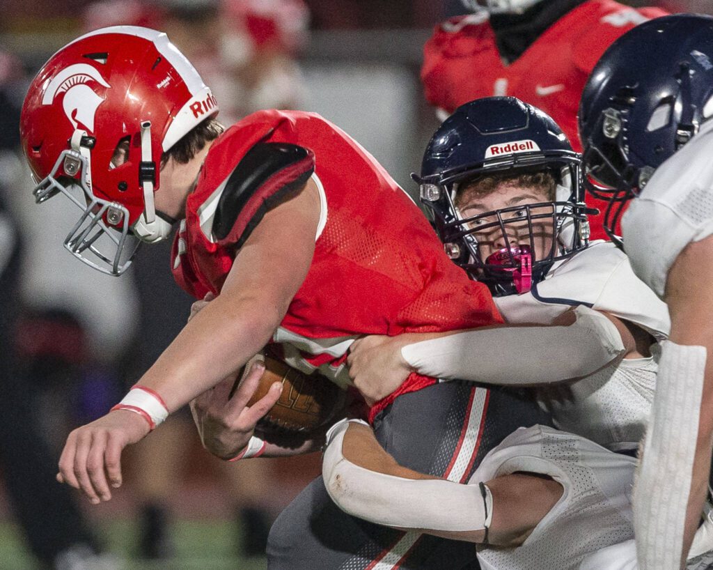 Multiple Alrington players tackle a Stanwood player during the game on Friday, Sept. 29, 2023 in Stanwood, Washington. (Olivia Vanni / The Herald)
