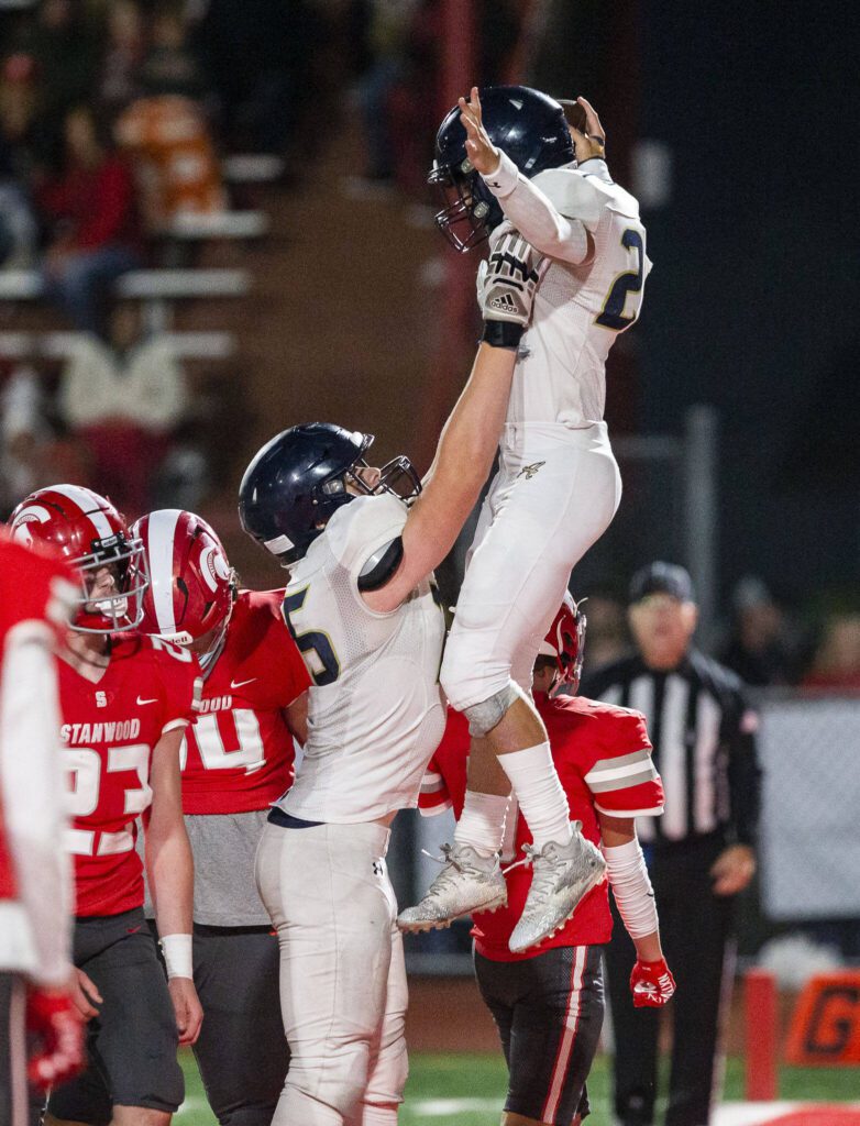 Arlington’s Caleb Reed is lifted in the air after scoring a touchdown during the game against Stanwood on Friday, Sept. 29, 2023 in Stanwood, Washington. (Olivia Vanni / The Herald)
