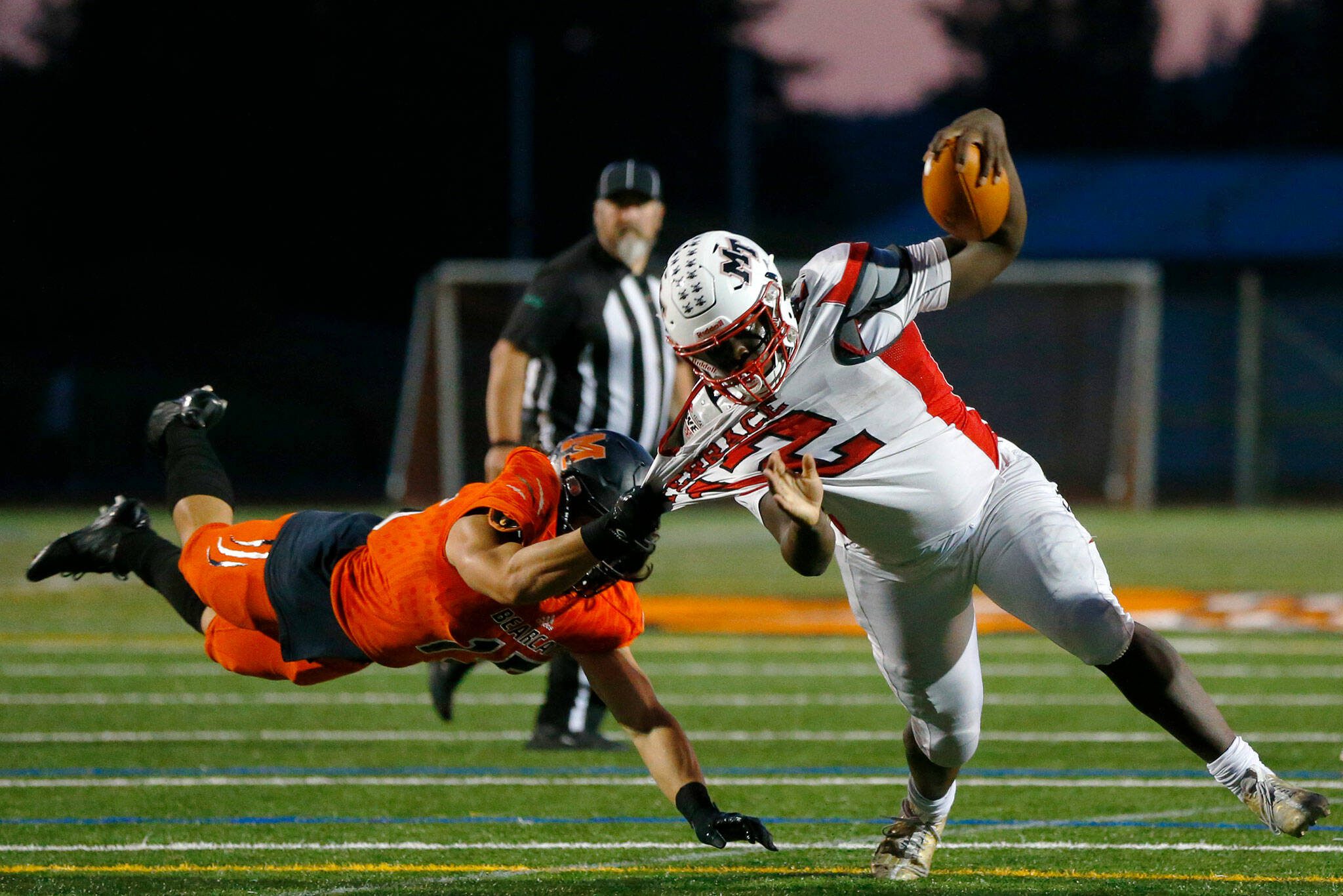 Mountlake Terrace’s Zaveon Jones is pulled to the ground by a diving Nicholas Mouser of Monroe on Friday, Sept. 29, 2023, at Monroe High School in Monroe, Washington. (Ryan Berry / The Herald)
