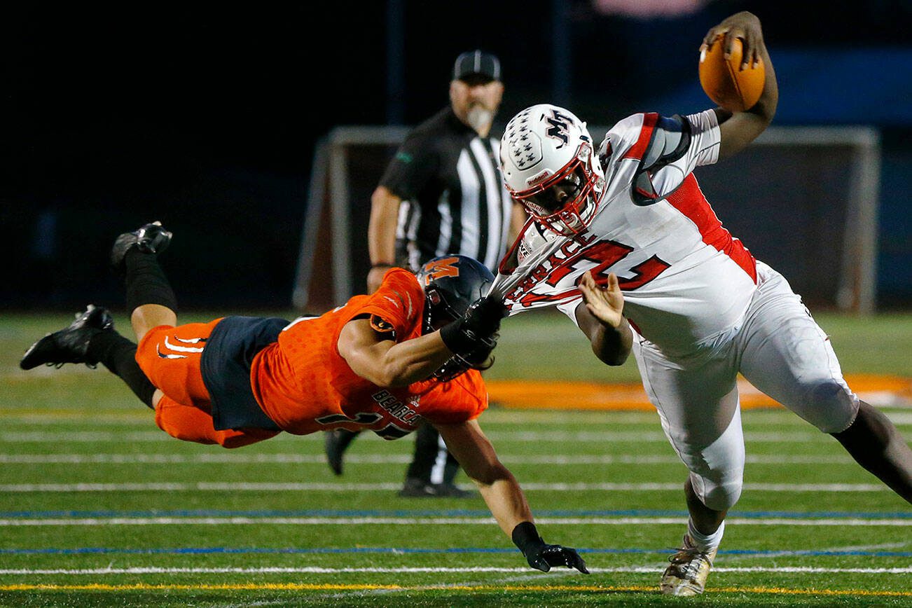 Mountlake Terrace’s Zaveon Jones is pulled to the ground by a diving Nicholas Mouser of Monroe on Friday, Sept. 29, 2023, at Monroe High School in Monroe, Washington. (Ryan Berry / The Herald)