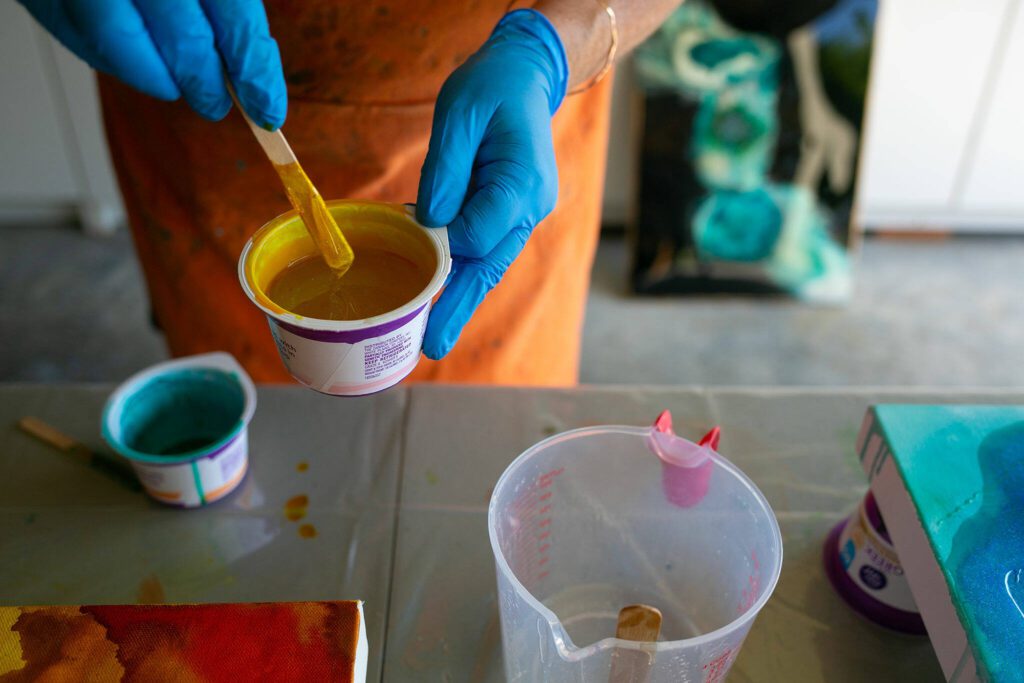 Downes mixes ink into a cup of resin. (Ryan Berry / The Herald)
