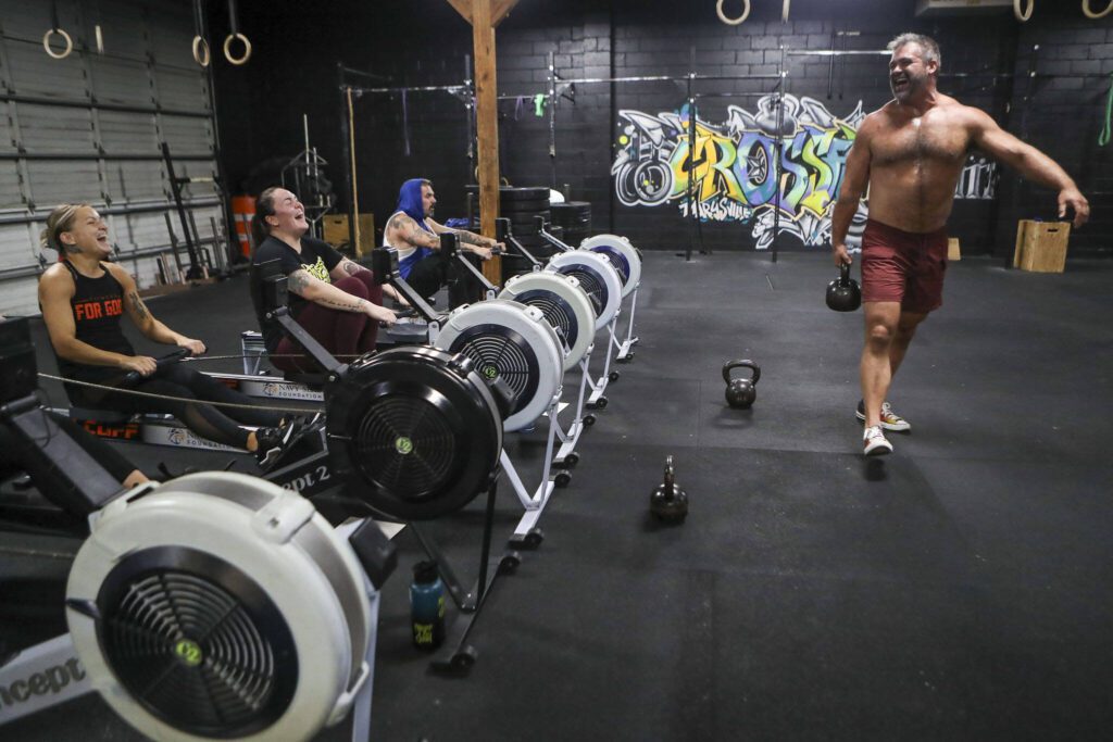 Adam Olsen, right, smiles while completing training exercises during a class lead by Harrison Wolff at Remedy Athletics in Marysville, Washington on Wednesday, Oct. 11, 2023. (Annie Barker / The Herald)
