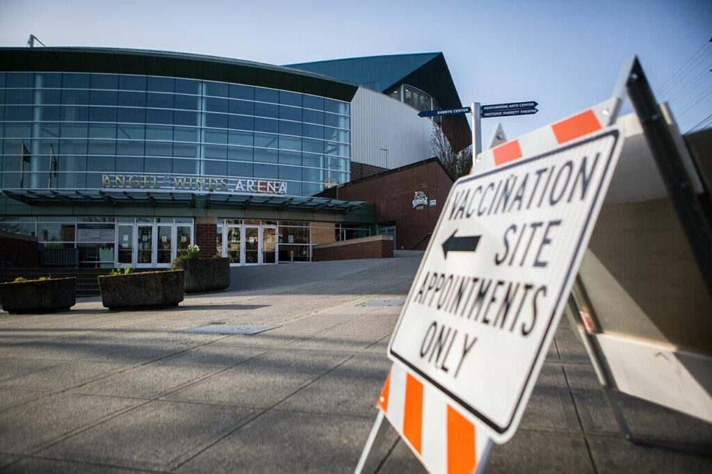 Stenczie Morgan with Maxim Healthcare Services sets up one of the four vaccination stations at the Angel of the Winds Area vaccination site on Tuesday, April 6, 2021 in Everett, Washington. (Olivia Vanni / The Herald)
