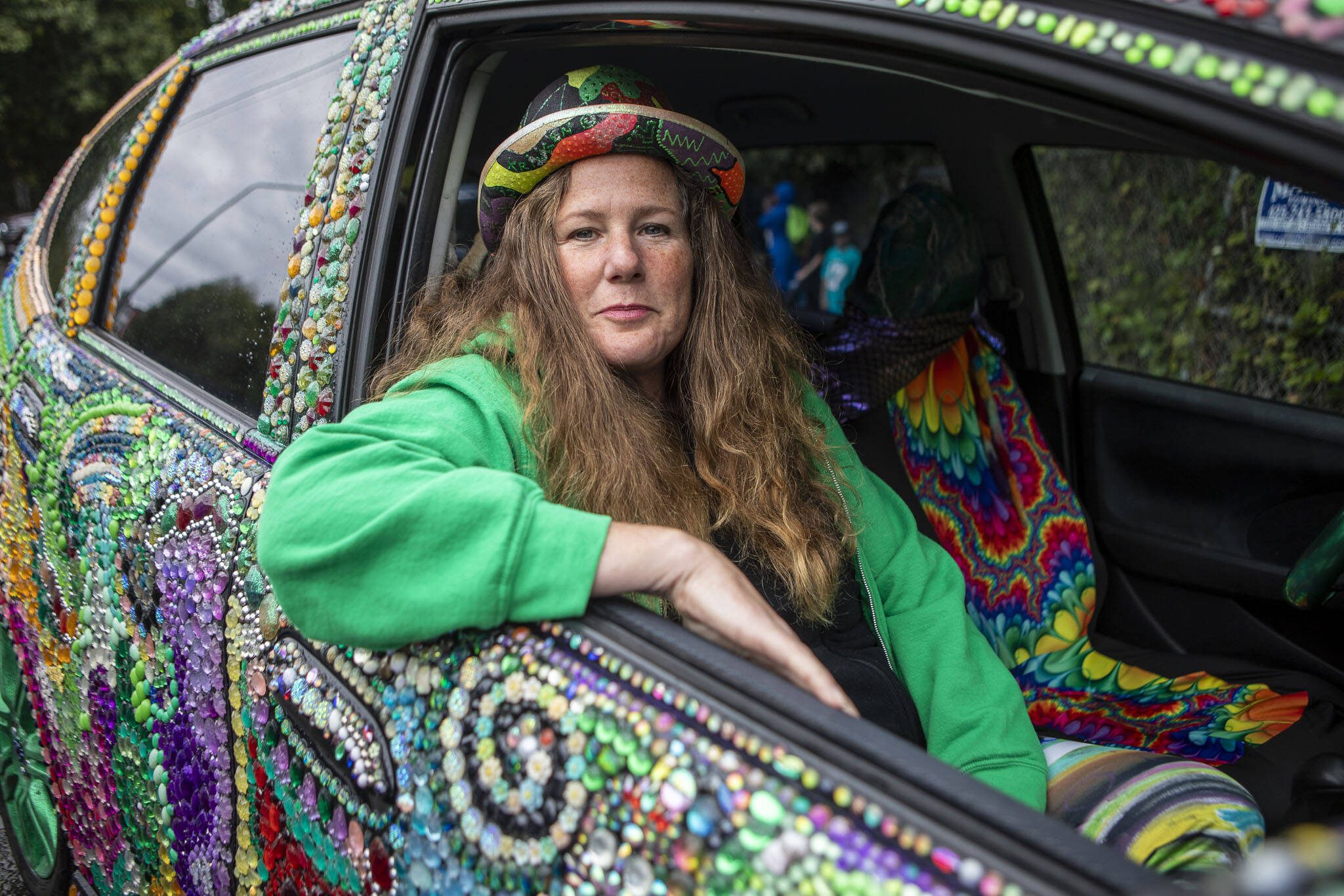 Shannon Kringen poses for a photo with her jeweled car at 2411 164th St SW in Lynnwood, Washington, on Saturday, Sept. 23, 2023. (Annie Barker / The Herald)