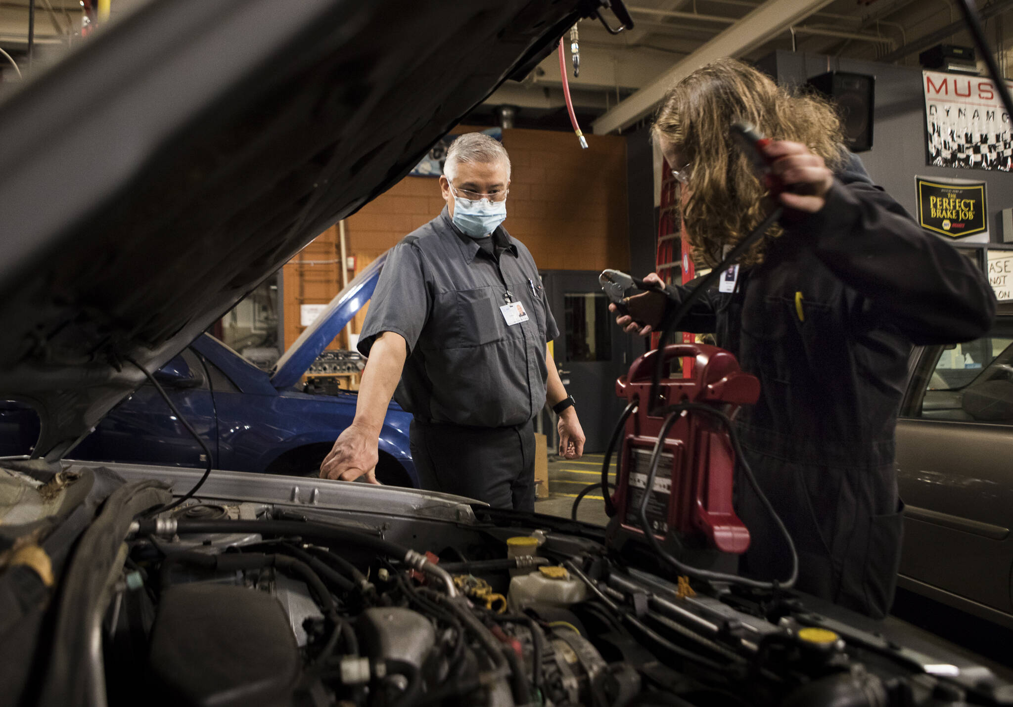 Richie del Puerto watches as a student works to jump start a car during class at Sno-Isle Technical Skills Center on Tuesday, Nov. 2, 2021 in Everett, Washington. (Olivia Vanni / The Herald)