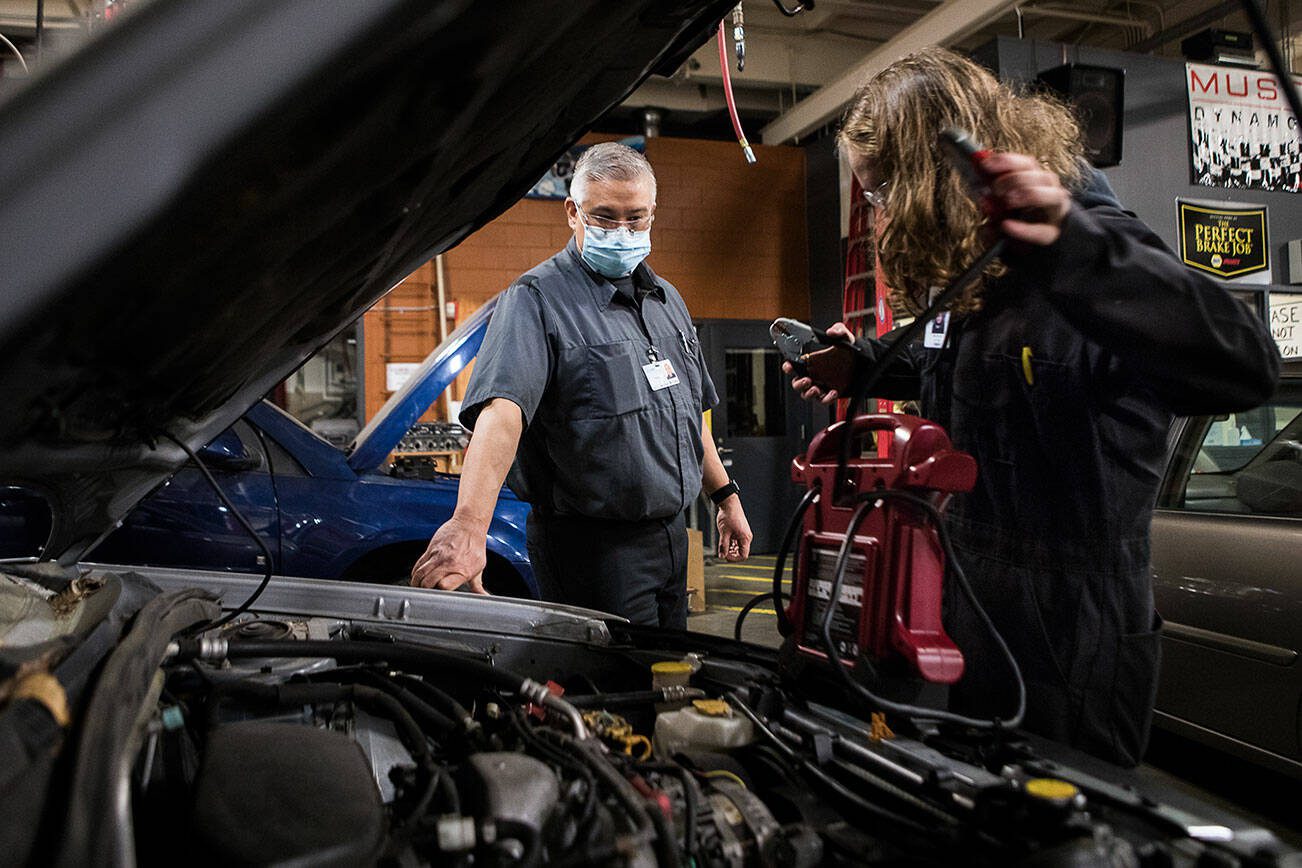 Richie del Puerto watches as a student works to jump start a car during class at Sno-Isle Technical Skills Center on Tuesday, Nov. 2, 2021 in Everett. (Olivia Vanni / The Herald)