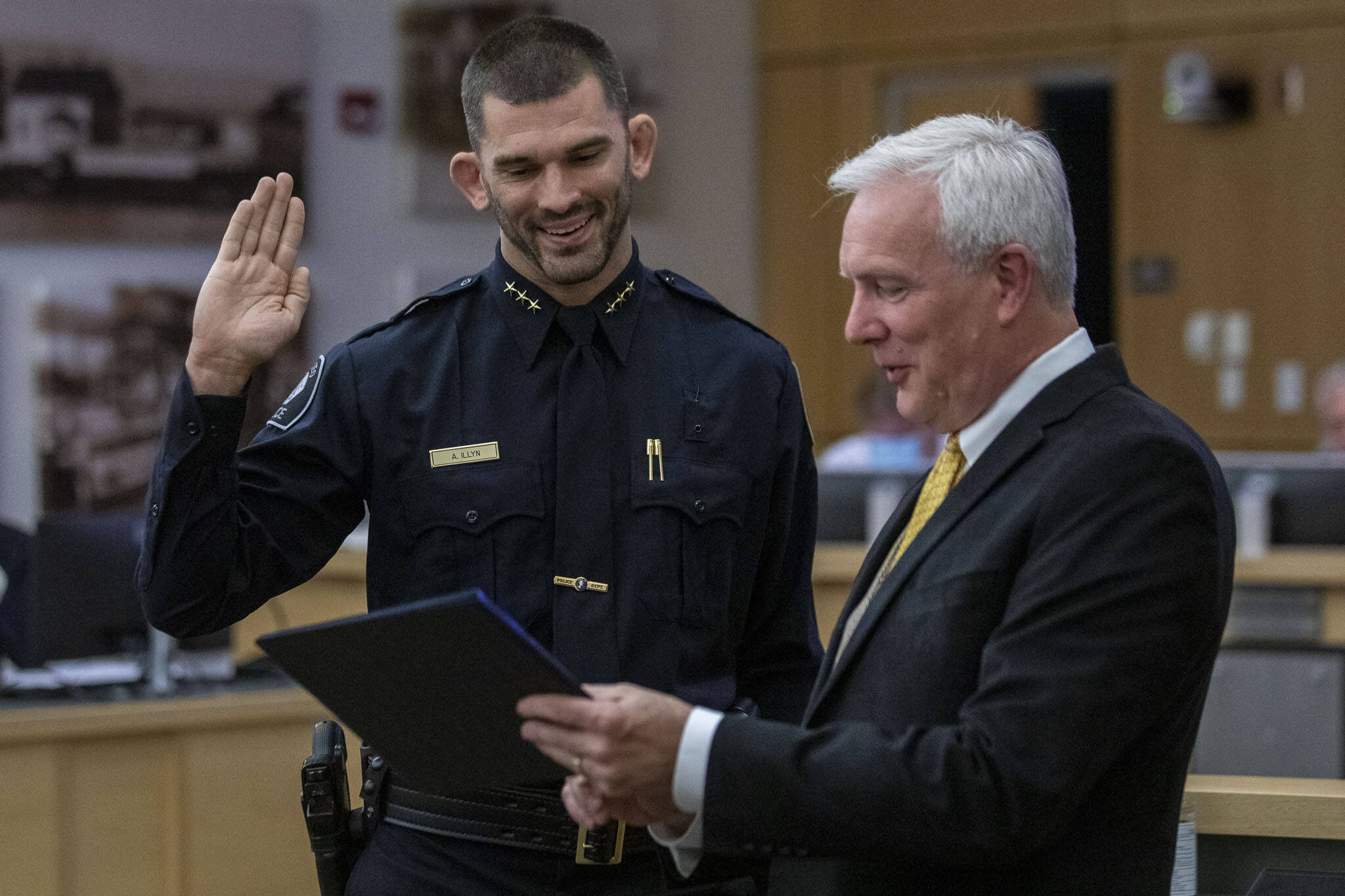 Andy Illyn, 37, left, is sworn in as the new Mukilteo Police Chief by Mayor Joe Marine, right, at Mukilteo City Hall on Monday, Oct. 2, 2023. (Annie Barker / The Herald)