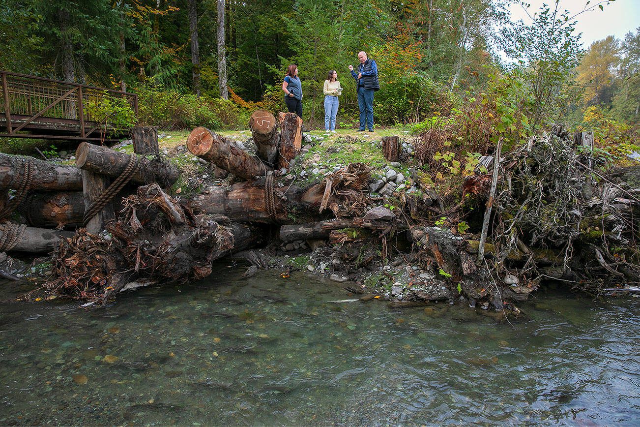 Keith Binkley, Natural Resources Manager at Snohomish County PUD, right, stands along the edge of the Sultan River while discussing habitat restoration efforts at Osprey Park on Friday, Oct. 6, 2023, in Sultan, Washington. (Ryan Berry / The Herald)