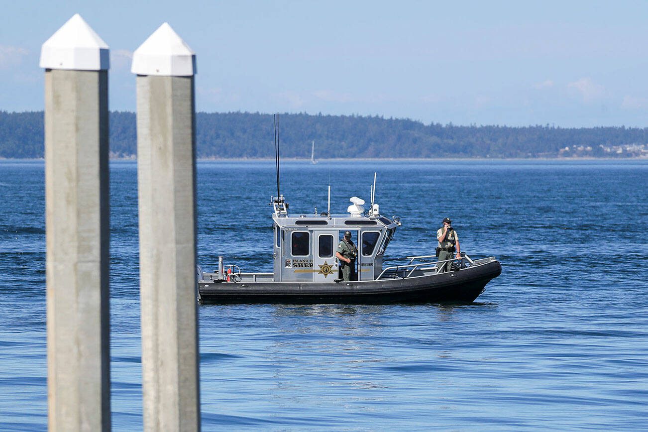Members of the Island County Sheriffs Office take part in the search for a chartered floatplane Monday afternoon in Freeland, Washington on August 5, 2022.  (Kevin Clark / The Herald)