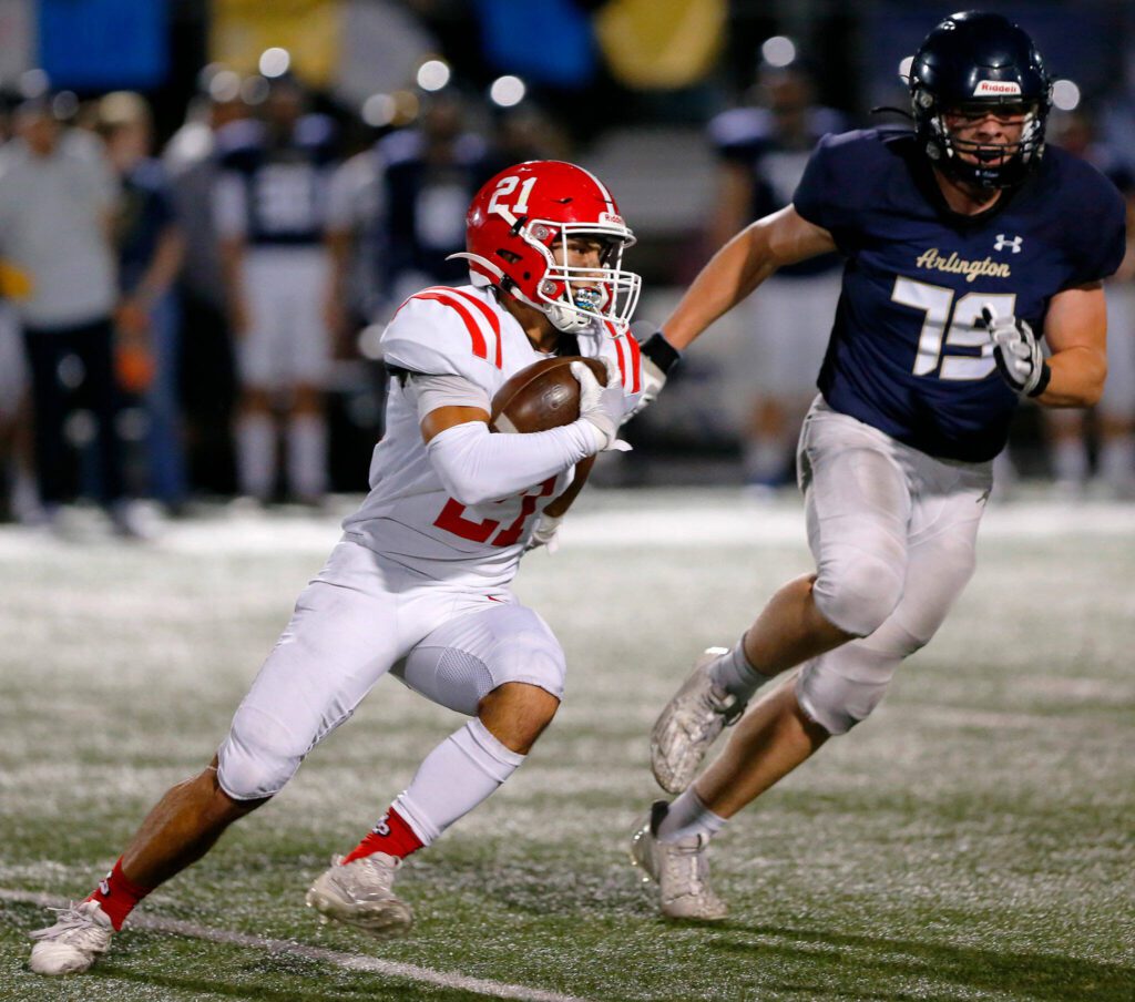 Marysville Pilchuck senior Kenai Sinaphet tries to get around the edge on a handoff against Arlington on Friday, Oct. 6, 2023, at Arlington High School in Arlington, Washington. (Ryan Berry / The Herald)
