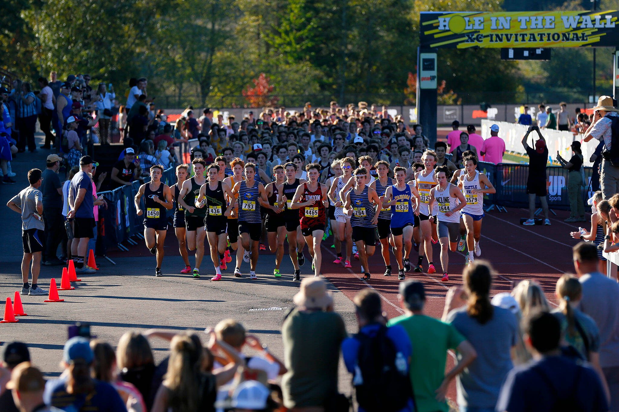 The pack stays together during the early portion of the Men’s Elite run during the Hole in the Wall Cross Country Invitational on Saturday, Oct. 7, 2023, at Lakewood High School in Arlington, Washington. (Ryan Berry / The Herald)