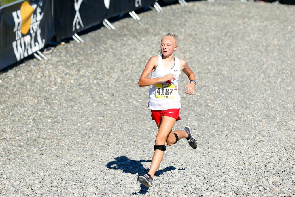 Stanwood runner Mary Andelin enters the final stretch while she cruises to a first place finish in the Women’s Varsity Gold run during the Hole in the Wall Cross Country Invitational on Saturday, Oct. 7, 2023, at Lakewood High School in Arlington, Washington. (Ryan Berry / The Herald)
