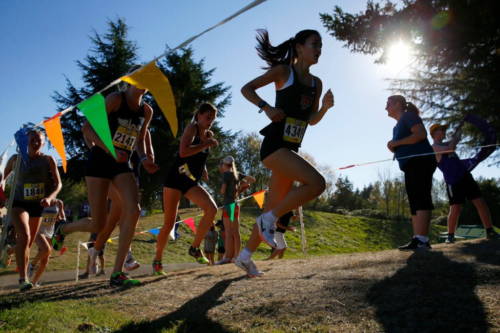 Runners head up a hill during the Hole in the Wall Cross Country Invitational on Saturday, Oct. 7, 2023, at Lakewood High School in Arlington, Washington. (Ryan Berry / The Herald)
