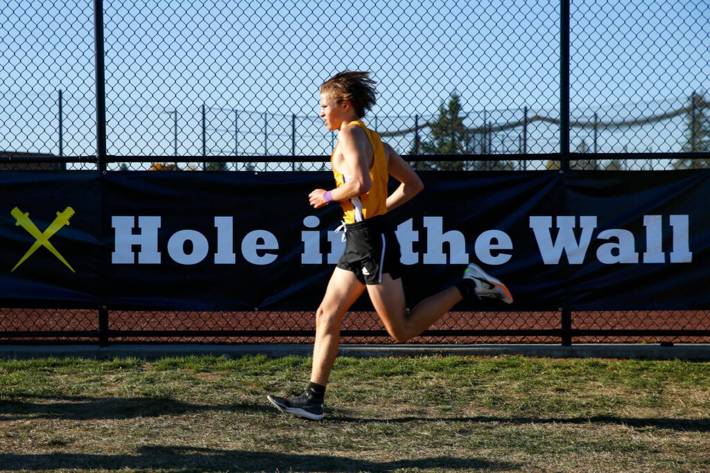 An athlete approaches the final stretch of the Men’s Elite run during the Hole in the Wall Cross Country Invitational on Saturday, Oct. 7, 2023, at Lakewood High School in Arlington, Washington. (Ryan Berry / The Herald)
