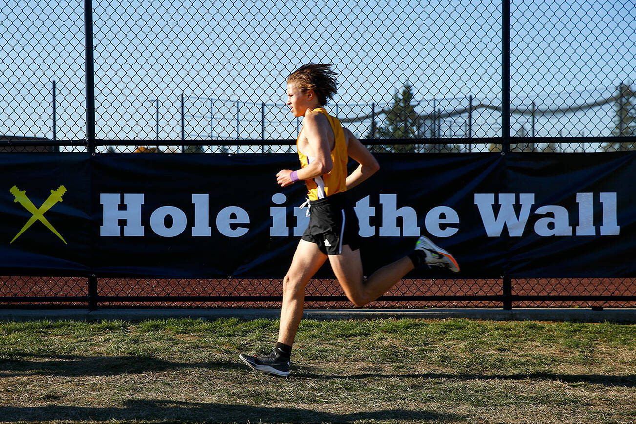 An athlete approaches the final stretch of the Men’s Elite run during the Hole in the Wall Cross Country Invitational on Saturday, Oct. 7, 2023, at Lakewood High School in Arlington, Washington. (Ryan Berry / The Herald)