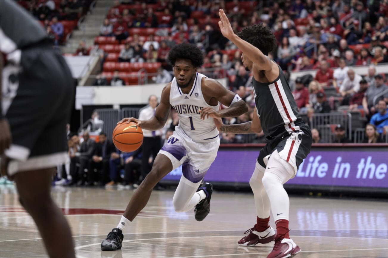 Washington forward Keion Brooks Jr. (1) drives against Washington State forward DJ Rodman, right, during the first half of an NCAA college basketball game Saturday, Feb. 11, 2023, in Pullman, Wash. Washington State won 56-51. (AP Photo/Dean Hare)