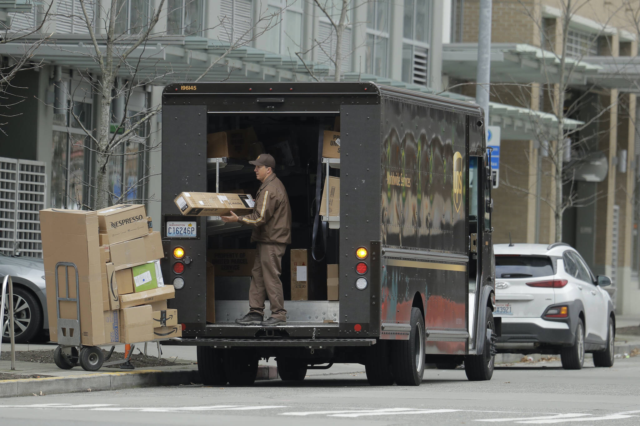 A United Parcel Service driver loads boxes during a delivery, in downtown Seattle, Washington. (AP Photo/Ted S. Warren)