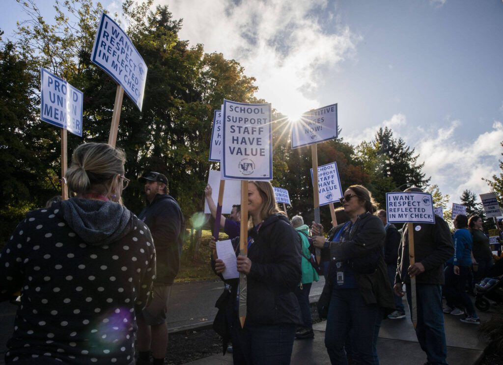 The sun breaks through the clouds while protestors chant outside of the Everett School Board Meeting on Tuesday, Oct. 10, 2023 in Everett, Washington. (Olivia Vanni / The Herald)
