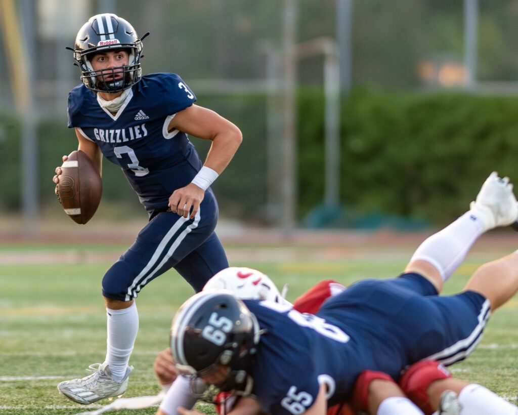 Glacier Peak quarterback Lucas Entler rolls out to pass during a game against Snohomish on Sept. 1 at Snohomish High School. (John Gardner / Pro Action Image)
