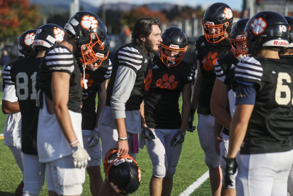 Senior quarterback Kaden LaPlaunt, center, talks to teammates between drills during Wednesday’s practice in Granite Falls. (Annie Barker / The Herald)
