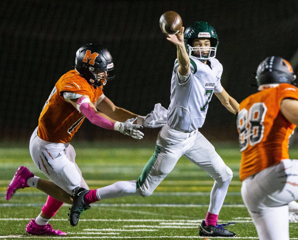 Edmonds-Woodway’s Steven Warren throws the ball while scrambling to avoid a sack during the game against Monroe on Friday, Oct. 13, 2023 in Monroe, Washington. (Olivia Vanni / The Herald)

