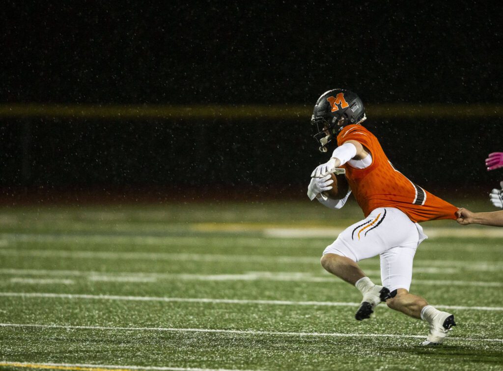 Monroe’s Mason Davis has his jersey pulled while running the ball during the game against Edmonds-Woodway on Friday, Oct. 13, 2023 in Monroe, Washington. (Olivia Vanni / The Herald)
