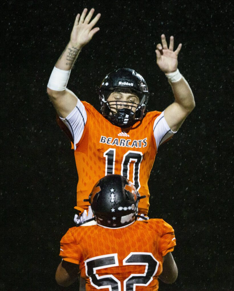 Monroe’s Tyler Lynch lifts teammate Blake Springer in the air in celebration of his touchdown during the game against Edmonds-Woodway on Friday, Oct. 13, 2023 in Monroe, Washington. (Olivia Vanni / The Herald)
