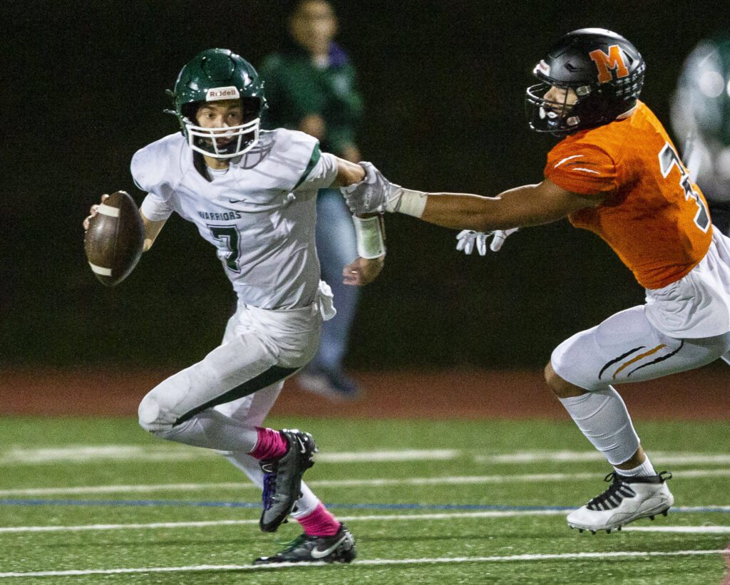 Monroe’s Iseah Canizales grabs the arm of Edmonds-Woodway’s Steven Warren while he tries to make a throw during the game on Friday, Oct. 13, 2023 in Monroe, Washington. (Olivia Vanni / The Herald)

