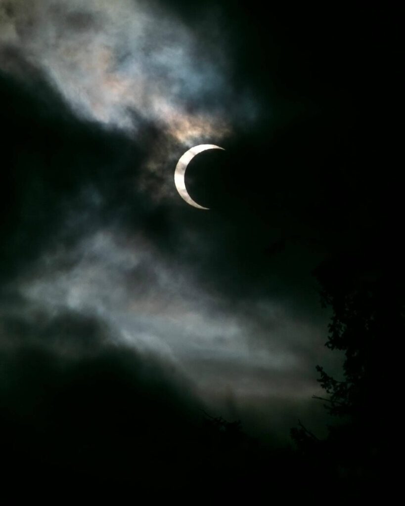 Clouds pass in front of the moon and sun as the two cross paths during an annular eclipse on Saturday, Oct. 14, 2023, seen from Everett, Washington. A total eclipse will be visible over parts of the United States in April 2024. (Ryan Berry / The Herald)
