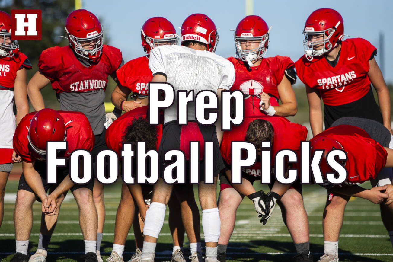 Stanwood's Michael Mascotti relays the next play to his teammates during football practice on Monday, Aug. 29, 2022 in Stanwood, Washington. (Olivia Vanni / The Herald)