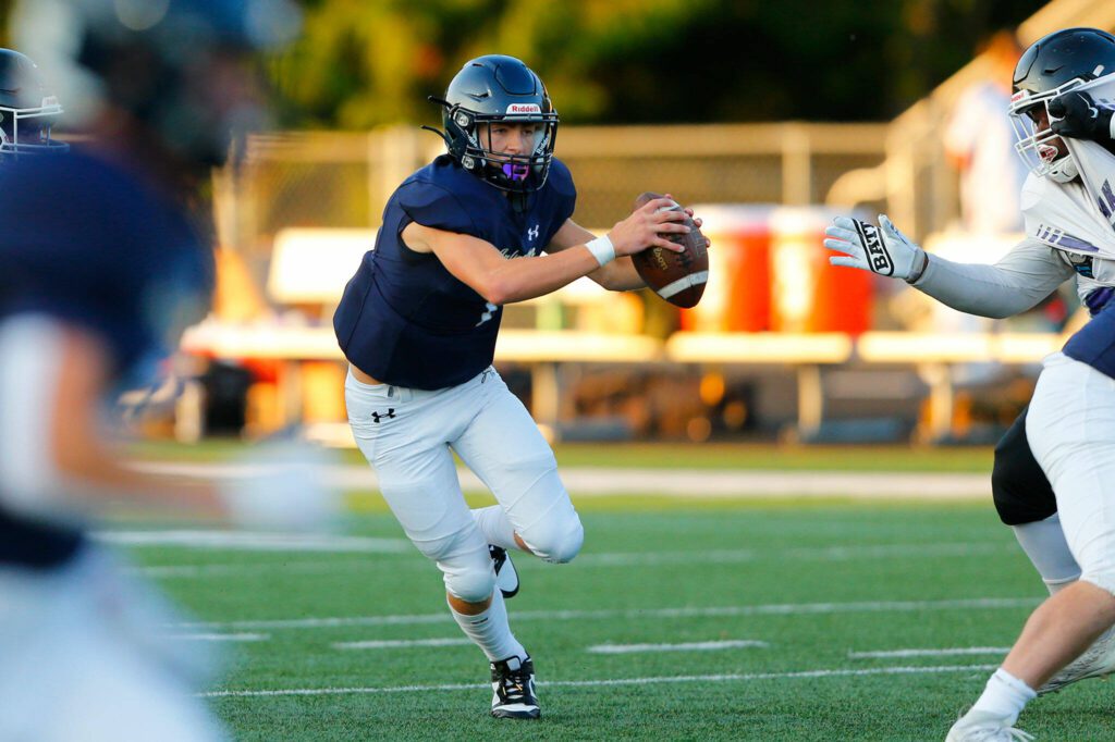Arlington quarterback Leyton Martin steps up in the pocket before taking a shot down the field during against Kamiak on Sept. 1 in Arlington. (Ryan Berry / The Herald)
