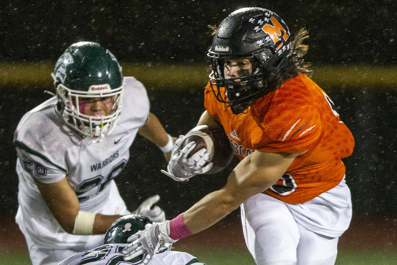 Monroe’s Nicholas Mouser escapes a tackle by Edmonds-Woodway's Krys Piechocinski during the game on Friday, Oct. 13, 2023 in Monroe, Washington. (Olivia Vanni / The Herald)