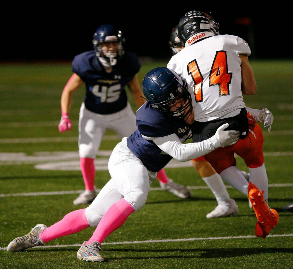 Monroe’s Ryan Miller is hit by Arlington’s Bookie Cramer right as he catches the ball on Friday, Oct. 27, 2023, at Arlington High School in Arlington, Washington. (Ryan Berry / The Herald)
